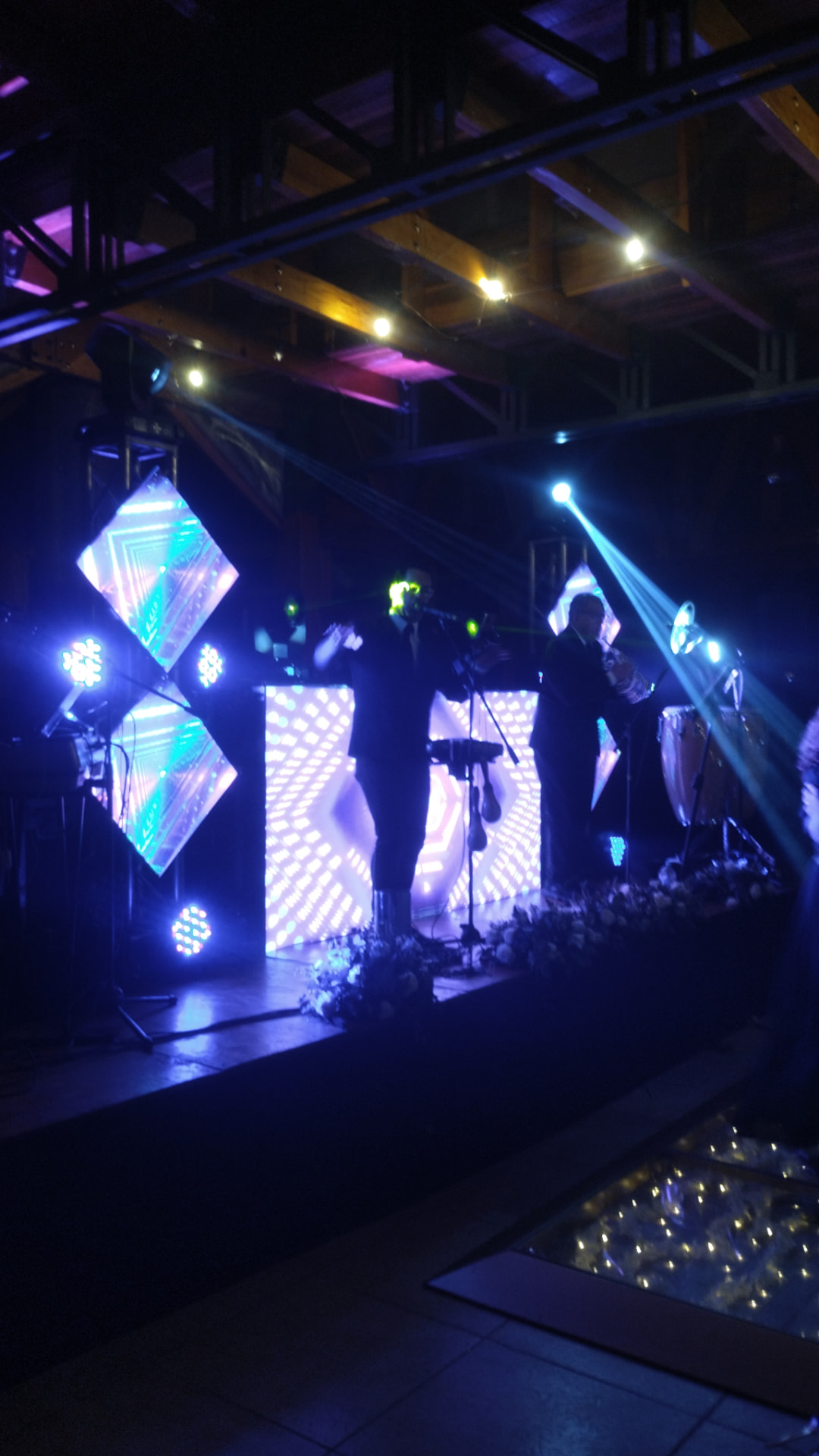Orquesta en vivo sobre tarima con pantalla LED de fondo en un concierto